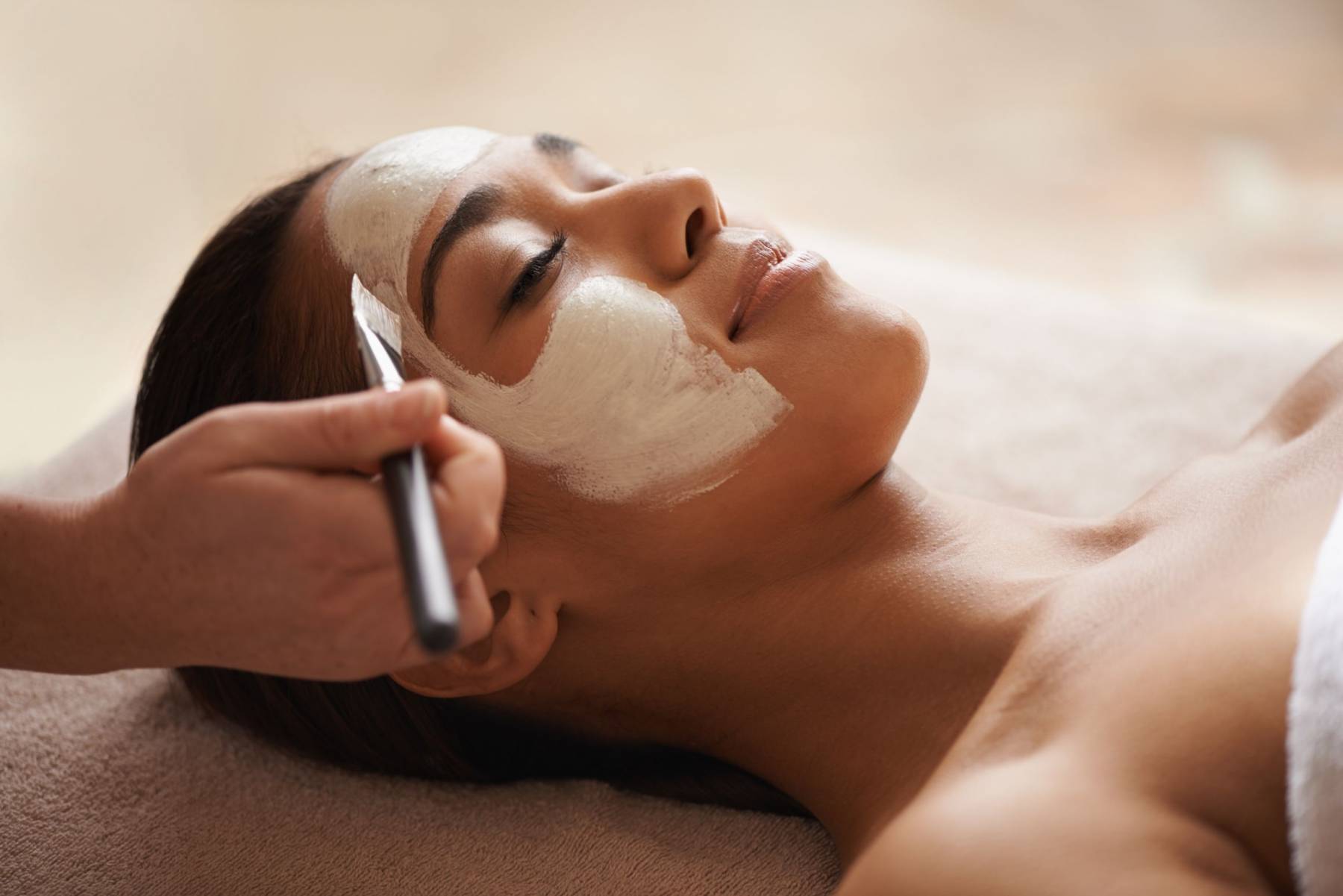 Application d'un peeling aux algues en poudre sur le visage pendant une séance de soin