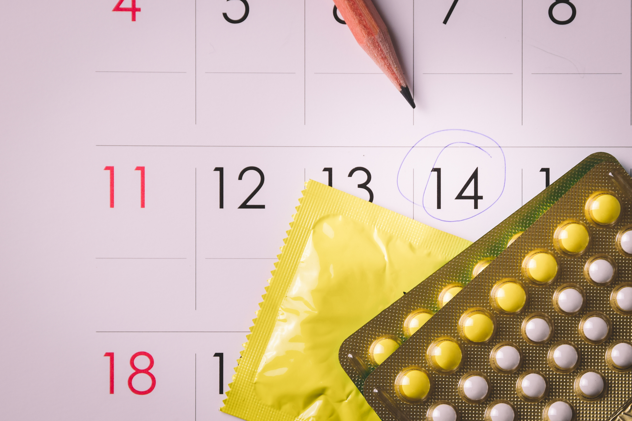 Calendrier menstruel et protections périodiques sur une table claire